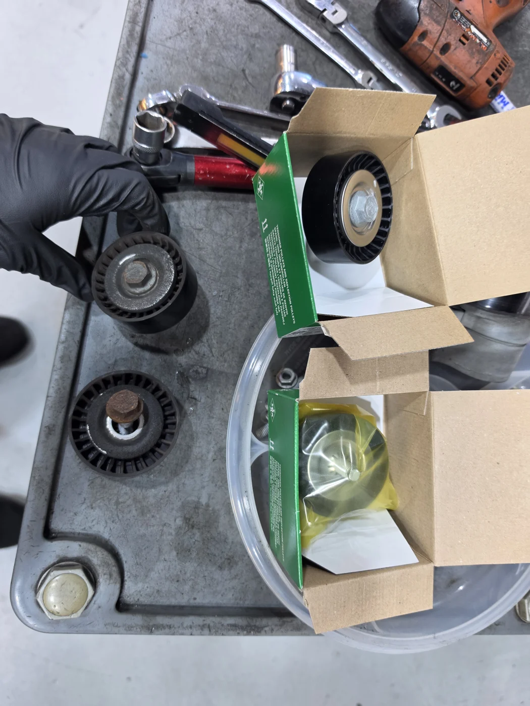 Removed parts and replacement pulleys and tensioner