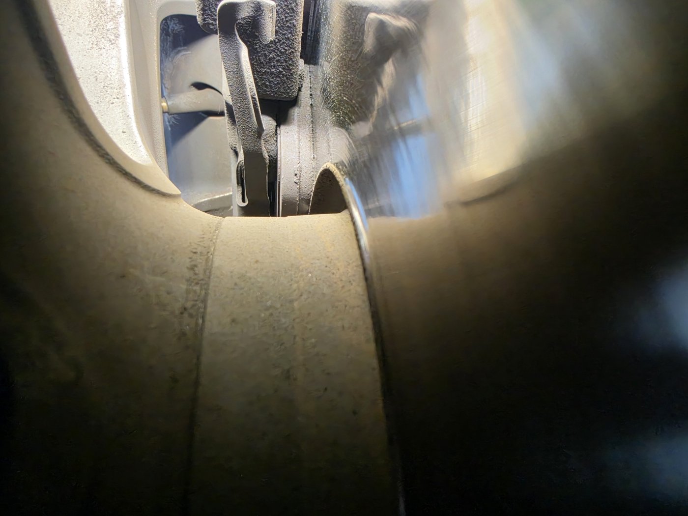 Hose connected to a brake fluid bleed port at the wheel.