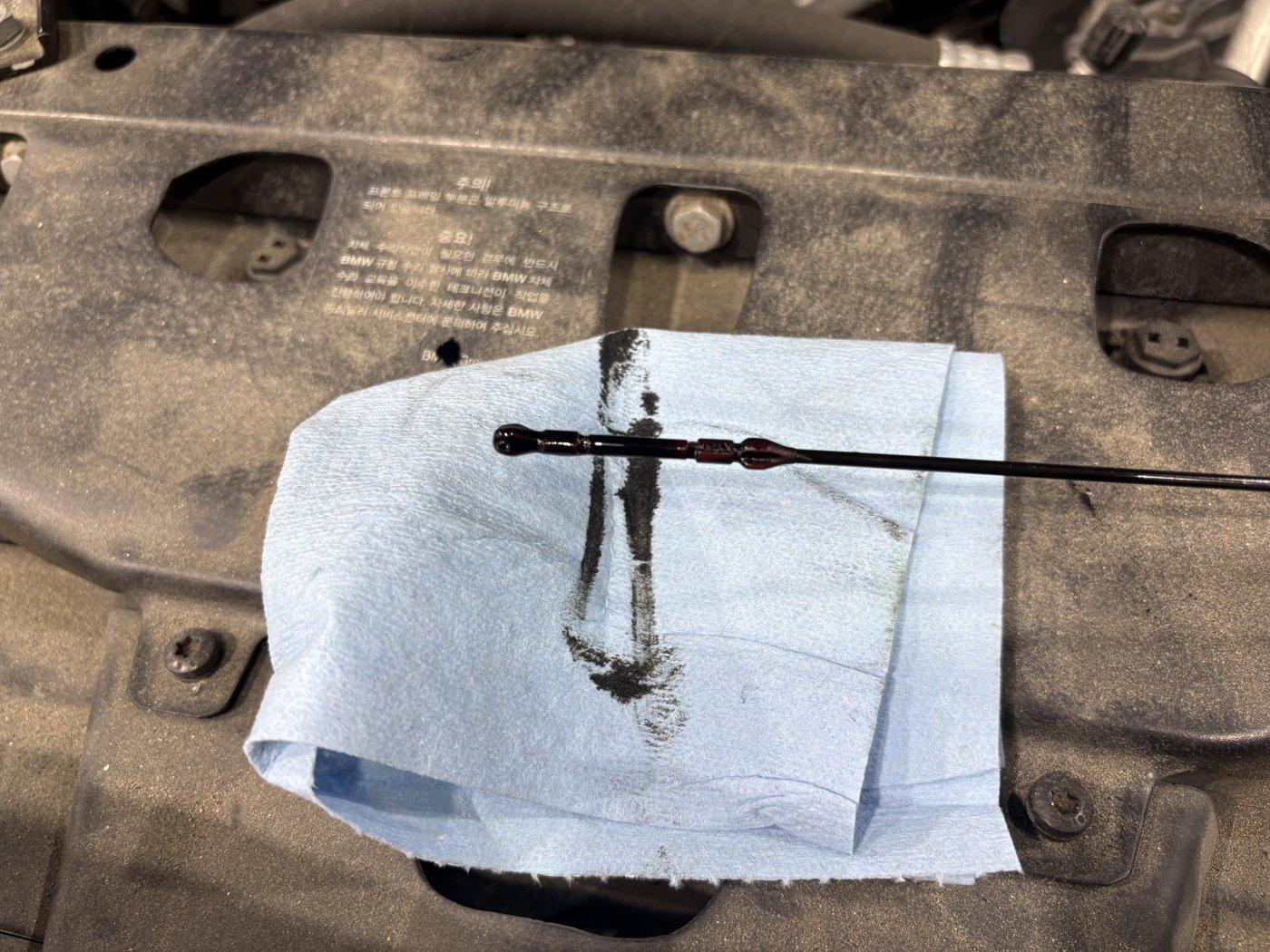 Checking the engine oil condition before draining.