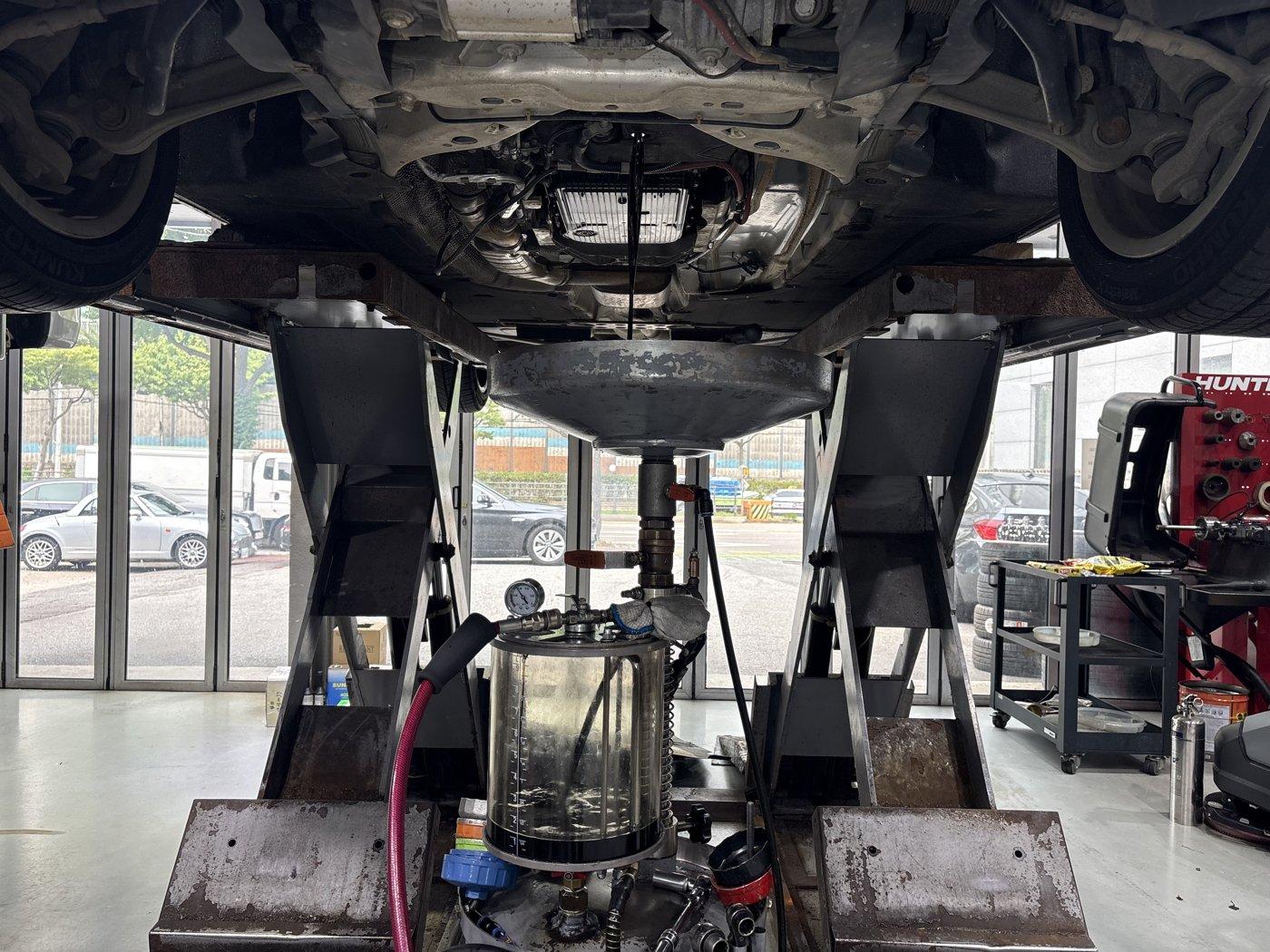 Draining the old engine oil on the lift.