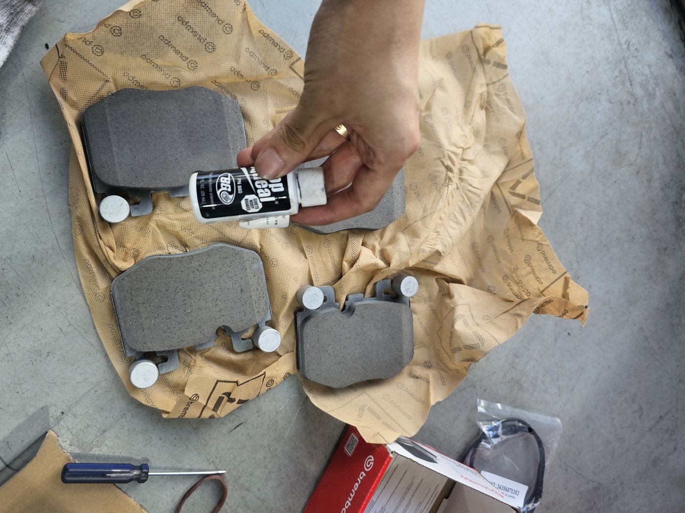 Applying noise-prevention treatment to the back of a new pad.