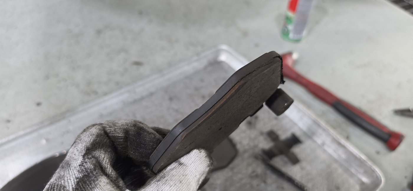 Friction-material side of a removed pad. We check the remaining thickness and wear pattern.