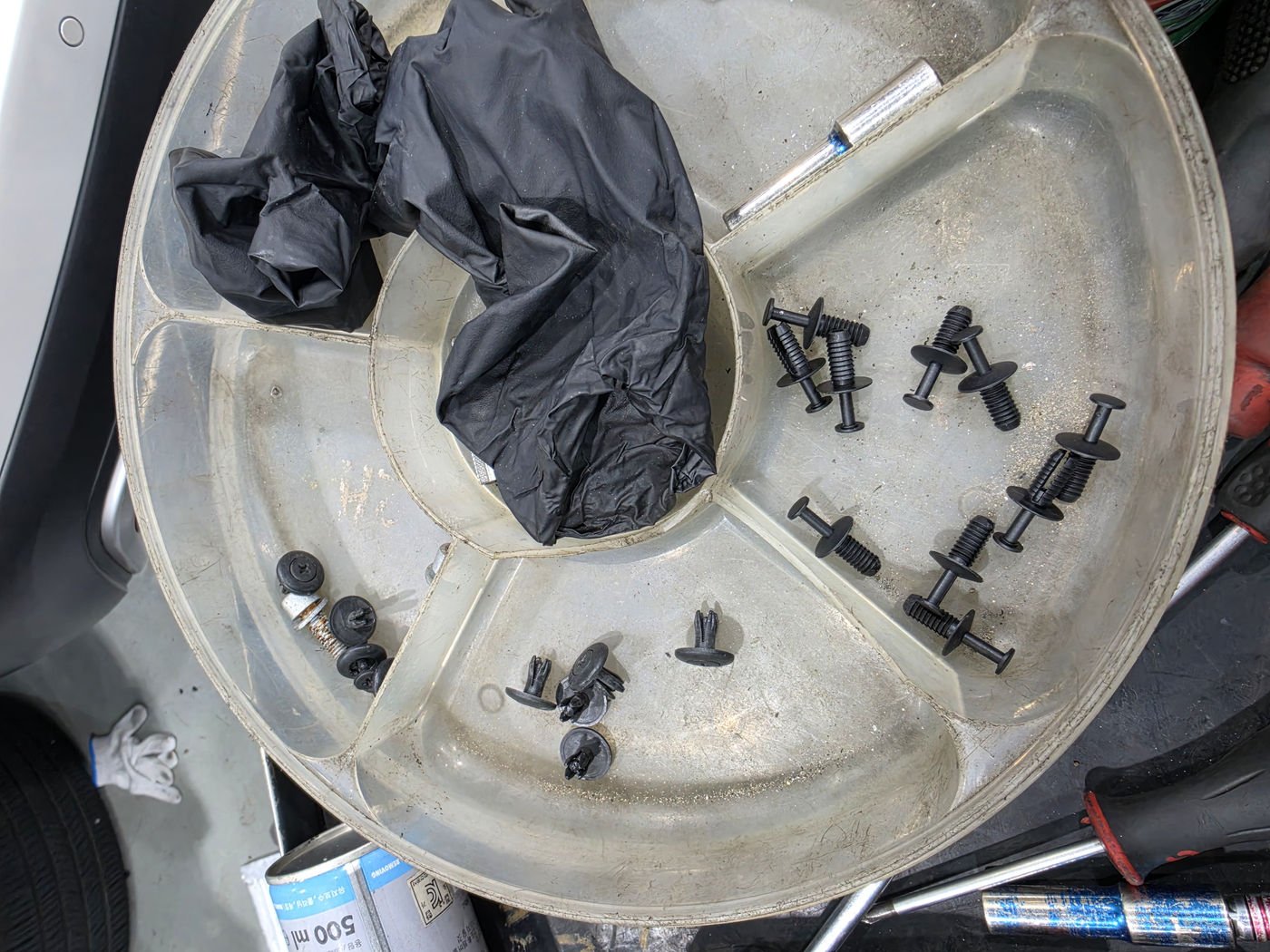 Securing the fasteners of the undercover that had been removed
