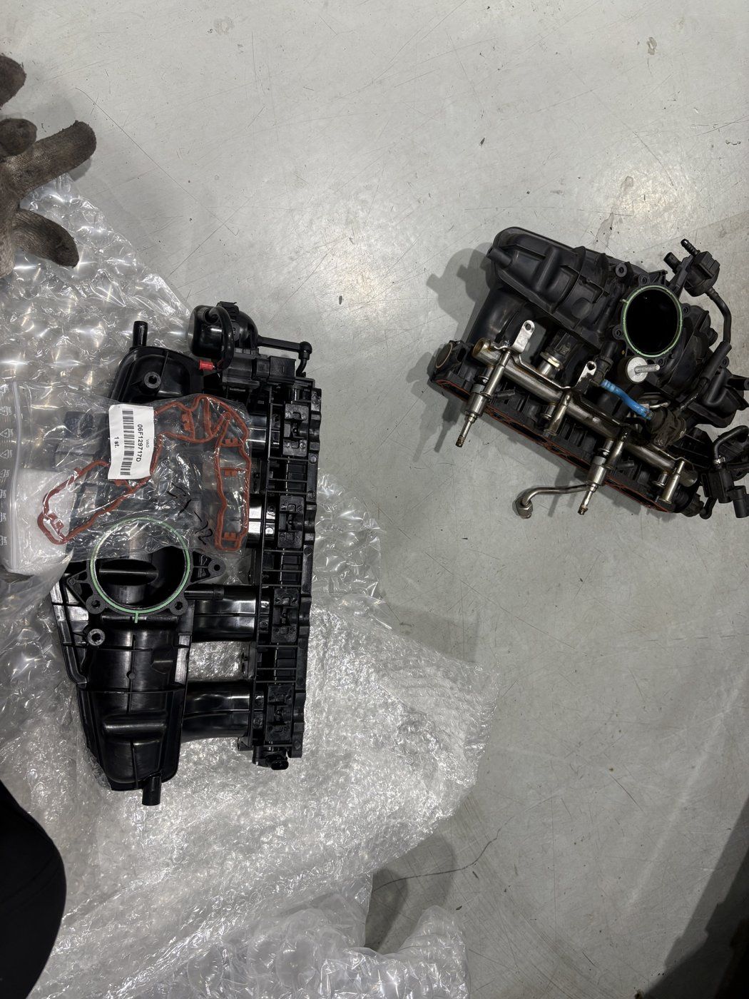 The removed intake manifold beside its replacement