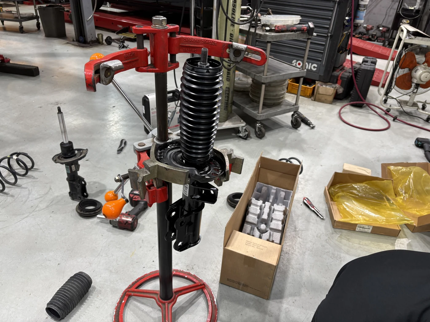 Assembling the front strut using a spring compressor.