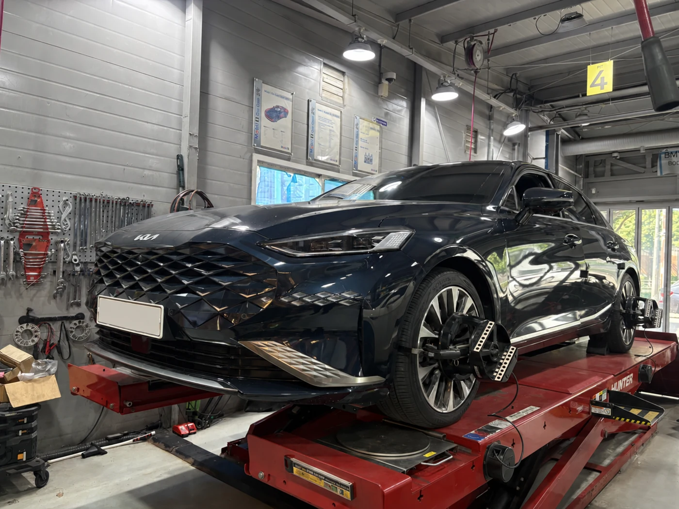 The actual Kia K8 on the alignment lift.