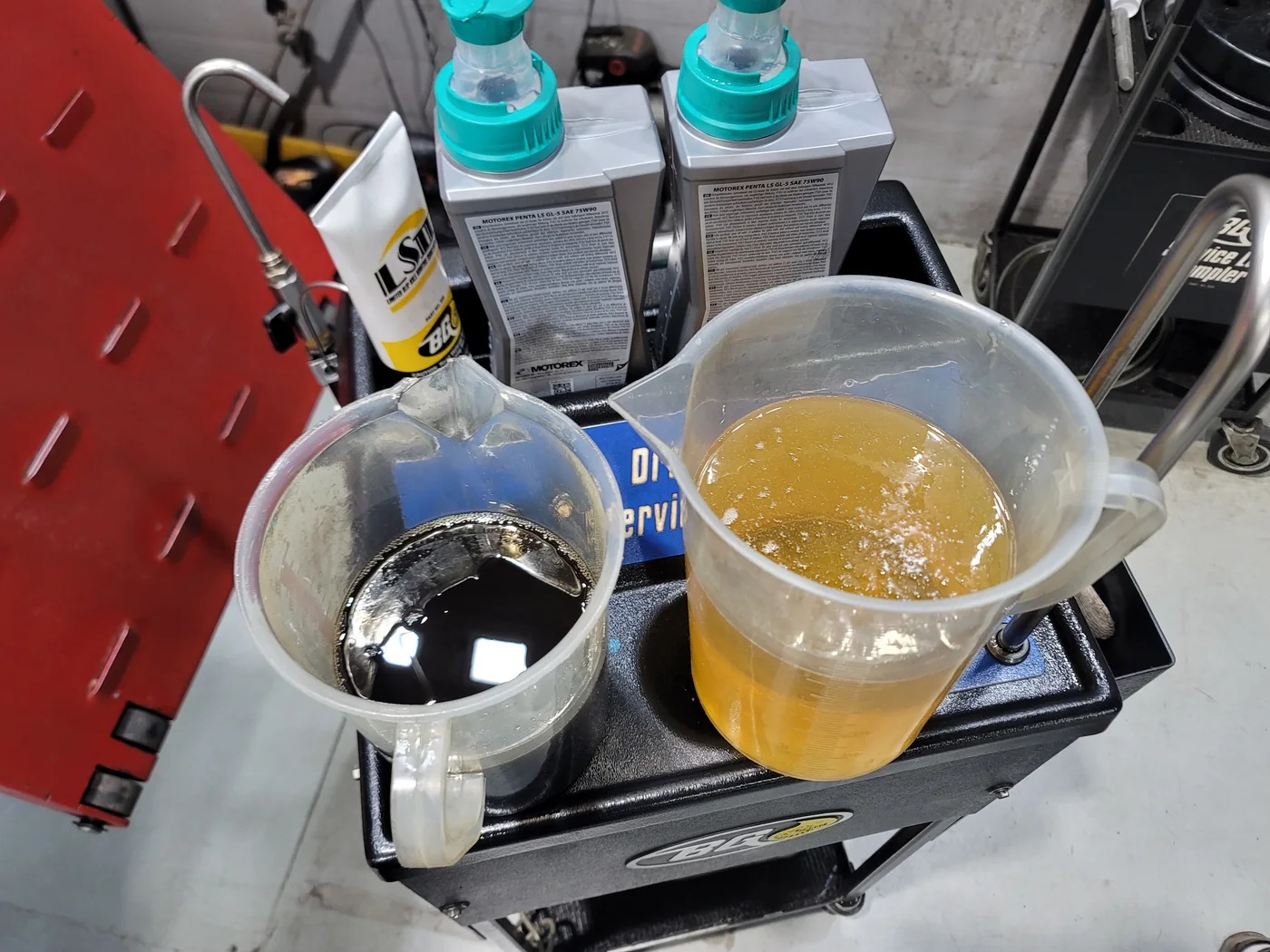 Drained differential oil beside the prepared fresh oil