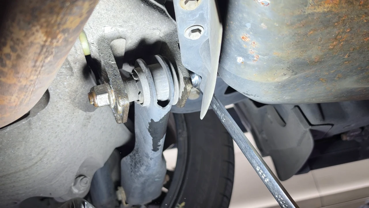 Checking movement at a rear adjustment-arm joint